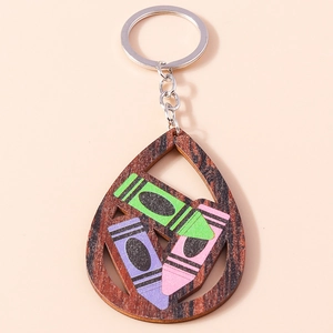 Detail of wooden teardrop keychain with colorful crayon prints and silver metal ring