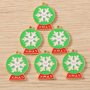 Detailed close-up of six Christmas enamel charms with XMAS text on a wooden background