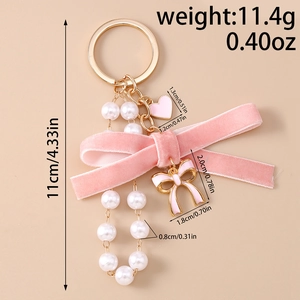 Pink velvet bow keychain with pearl tassel and heart charm showing detailed dimensions