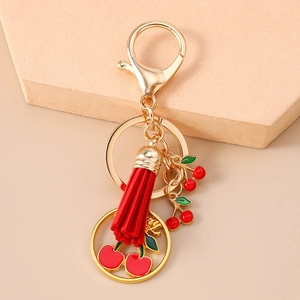 Détail du porte-clés à glands cerise en alliage doré avec pendentifs en émail rouge brillant