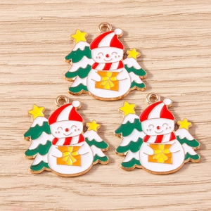 Detailansicht der Emaille Schneemann und Weihnachtsbaum Anhänger auf Holzgrund