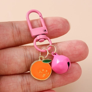 Pink keychain with orange charm and bell pendant accessory for handbags and keys