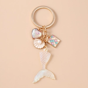 Detail of mermaid tail keychain with iridescent heart charm and pearl shell pendant