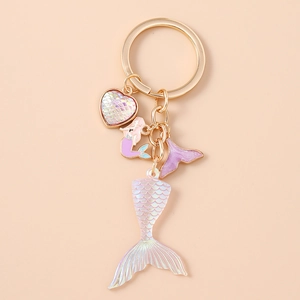 Detailed close-up of mermaid tail keychain with holographic scales and gold finish charms