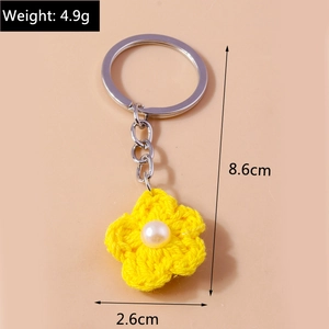 Close-up of yellow knitted flower keychain with pearl center showing 8.6cm length size