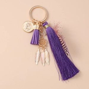 Detail of bohemian dreamcatcher keychain with purple tassels and golden feathers