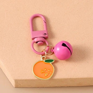 Detail of cute orange pendant keychain with pink bell and lobster clasp on display board