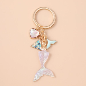 Detail view of mermaid tail keychain featuring translucent charms and golden ring