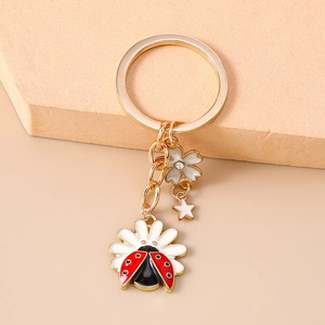 Detailed close-up of ladybug on daisy keychain with gold-plated chain and star charm