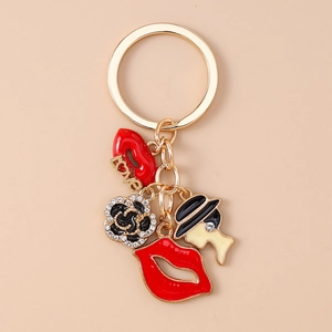 Detail of gold keychain featuring red lips, black and white rose, and fashion lady charm