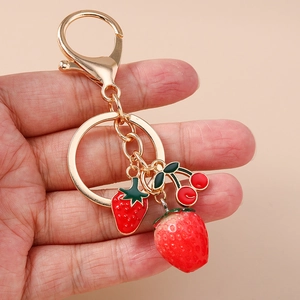 Creative fruit keychain featuring realistic strawberry and cherry charms on a gold ring