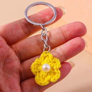 Handmade crochet yellow flower keychain with white pearl center on a silver metal ring