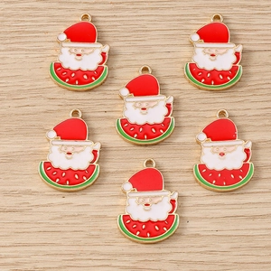 Flat lay of alloy Santa Claus watermelon charms with gold edges on wood surface