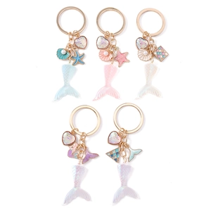 Fashionable mermaid tail keychains with iridescent shells and colorful hearts charms