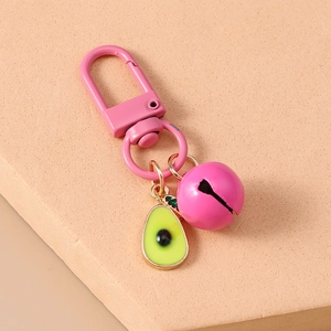 Detail of pink metal carabiner with large matte bell and cute resin avocado charm