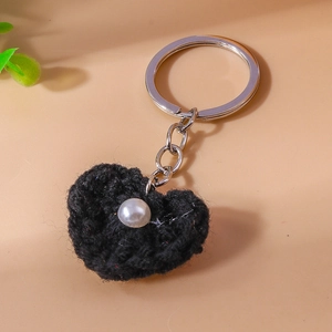 Detailansicht des handgestrickten schwarzen Herz-Schlüsselanhängers mit Perle und Ring