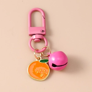 Close-up of cute pink bell and orange slice pendant keychain with clasp for bags