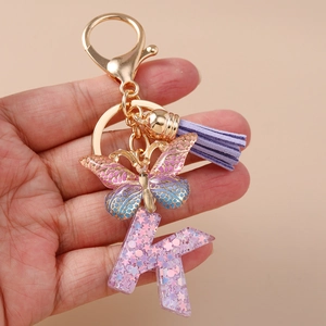 Portachiavi a farfalla alla moda con lettera K, nappa viola e ciondoli con paillettes lucide