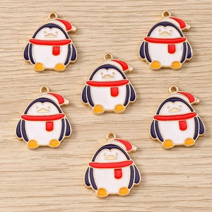 Macro detail of six cute enamel penguin pendants with red Christmas hats for DIY jewelry