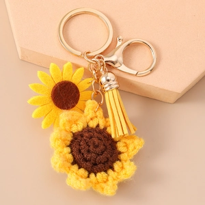 Dettaglio del portachiavi a girasole all'uncinetto con fiore in feltro e nappa in similpelle gialla