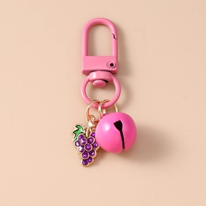 Detail of pink metal spring clasp with a purple grape charm and a large matching pink bell