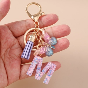 Portachiavi con farfalla e nappa viola con ciondolo lettera M in resina glitterata