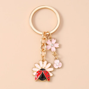 Detail of floral keychain with cherry blossom, pearl flower and ladybug charm pendants
