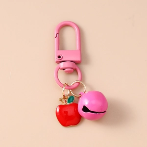 Close-up of pink lobster clasp with red apple enamel pendant and matching small bell