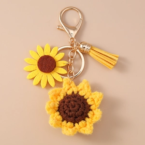 Dettaglio portachiavi a girasole all'uncinetto con nappa gialla e chiusura dorata