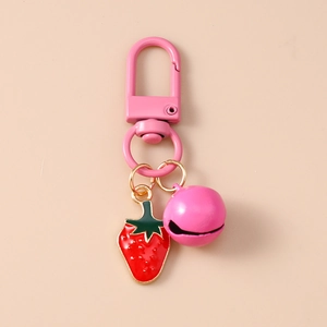 Detail view of pink frosted strawberry keychain with bell and enamel fruit pendant