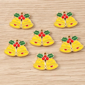 Flat lay of Christmas bell enamel charms with red berries for DIY jewelry making