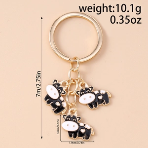 Detail of cartoon cow keyrings with gold rings showing dimensions and 10.1g weight