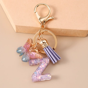 Dettaglio portachiavi con nappa viola, ciondolo a farfalla e lettera Z in resina con paillettes