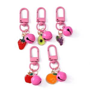 Pink fruit keychain set with metal bell and enamel strawberry, avocado, and grape charms