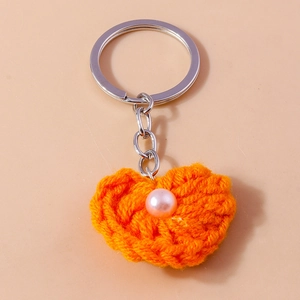 Detailansicht des handgefertigten gestrickten Herz-Schlüsselanhängers mit Perle und Ring
