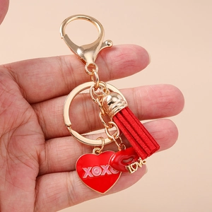 Roter Herz Schlüsselanhänger mit Quaste und goldenem LOVE Anhänger in der Hand