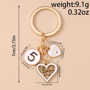 Detail of gold keychain featuring heart pendants with evil eye and I Love You engraving