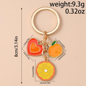 Detailed view of enamel orange and heart charms on a gold keychain with size dimensions