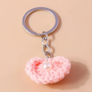 Detailansicht vom rosa gestrickten Herz-Schlüsselanhänger mit weißer Perle und Silberring