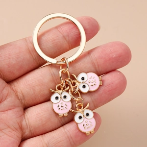 Porte-clés chouette doré avec trois jolis pendentifs en émail rose et blanc