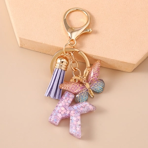 Dettaglio portachiavi lettera K con paillettes viola, stelle e nappa coordinata