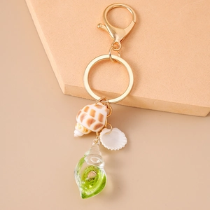 Detailed close-up of a creative summer beach shell keychain with green resin pendant