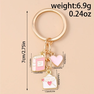 Detailed view of golden heart, book, and envelope charms on a 7cm fashion keychain