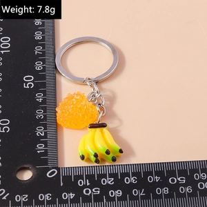 Détail d'un porte-clés banane créatif avec perle orange montrant un poids de 7,8g
