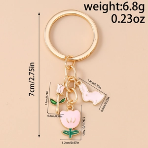 Detailed size measurement of pink tulip and rabbit charms on a gold keychain