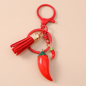 Detail view of red leather tassel and glossy chili pendants on fruit keychain