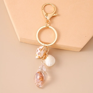 Detailed view of ocean-style shell keychain with golden lobster clasp and resin charms