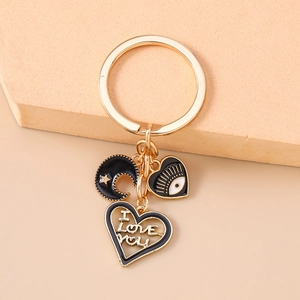 Detail of gold keychain with moon and evil eye heart charms plus I Love You pendant