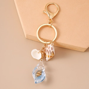 Detail of beach ocean shell keychain with sea conch and blue luminous pendant charm