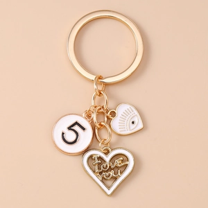 Detail of gold keychain with white enamel devil eye and I LOVE YOU heart charms